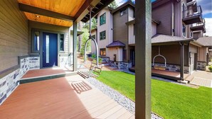 Eine überdachte Terrasse mit Schaukel und Kiesweg, umgeben von einem gepflegten Rasen.