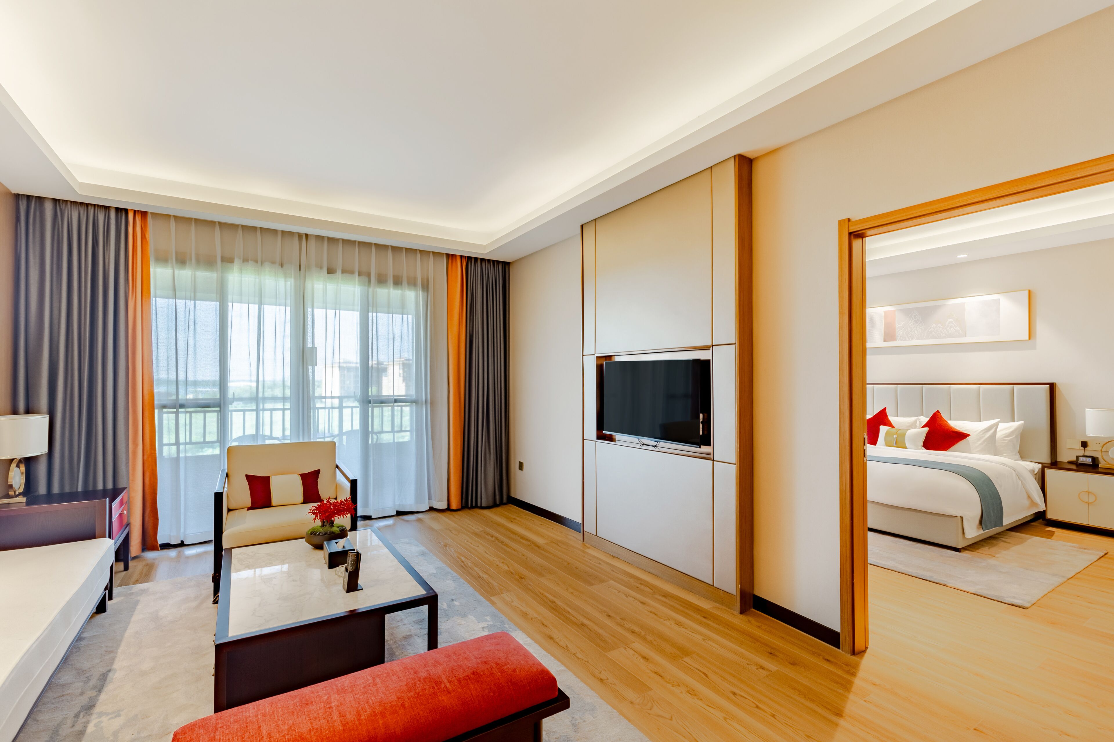 Una habitación de hotel con cama, televisión, sofá, mesa de centro y escritorio.