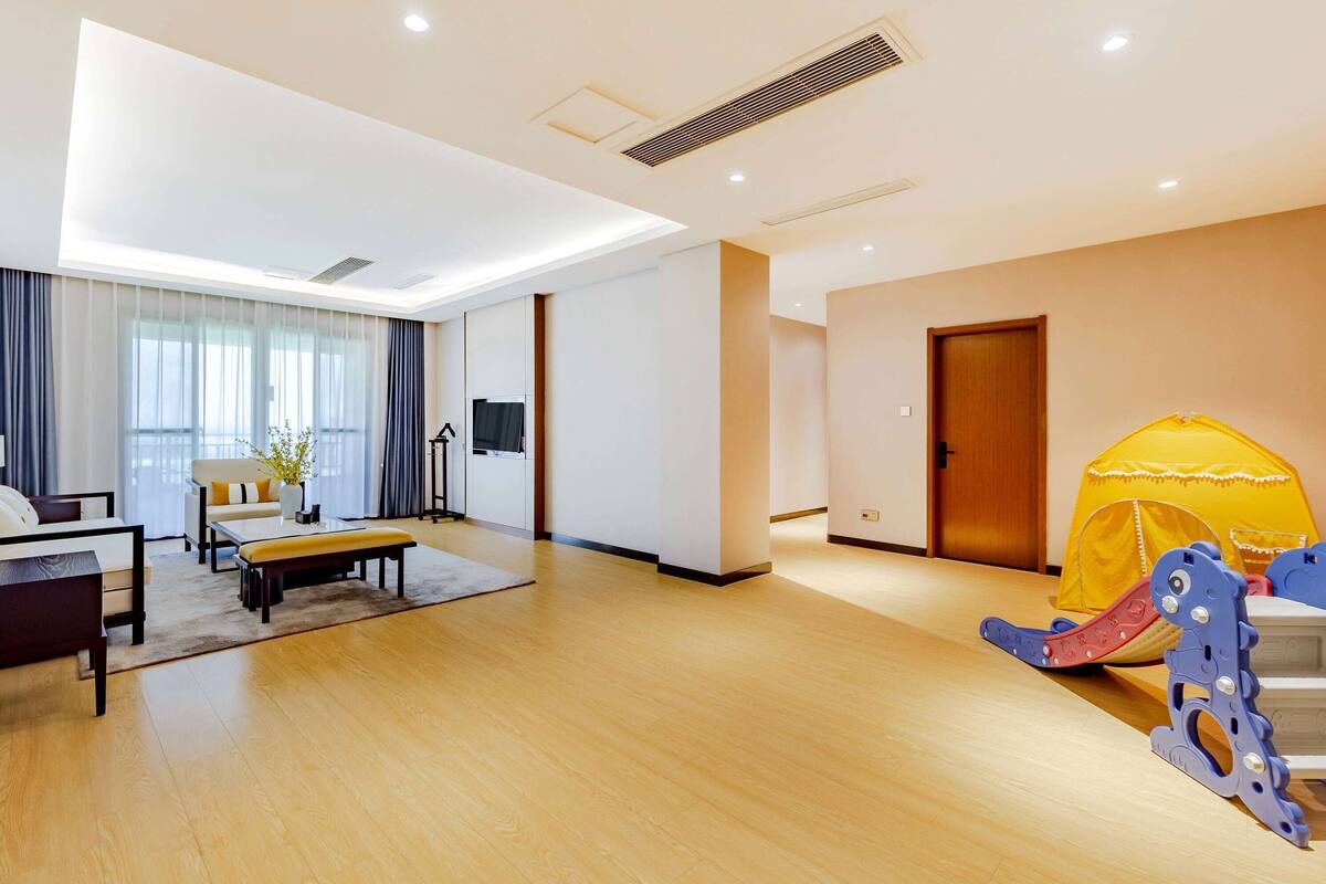 Un salon moderne avec un canapé, une table basse et une structure jaune en forme de tente.