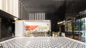 A spacious lobby with a patterned floor, a reception desk, and a modern reception area. - Wingate By Wyndham Wuhan Optics Valley (Wuhan)