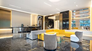 A modern lobby with a marble floor, a reception desk, and a seating area with sofas and armchairs. - Wingate By Wyndham Wuhan Optics Valley (Wuhan)