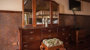 Een houten dressoir met meerdere lades en een spiegel erboven.