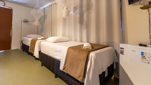 A hotel room with two beds, a television, and a minibar. - Pousada Recanto da Mata (Porto Seguro)