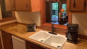 A kitchen with wooden cabinets, a double sink, a toaster, a coffee maker, and a dishwasher. - BEARADISE 1 - Five Min Walk To Downtown Banner Elk (Banner Elk)