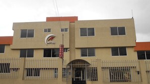 Un hotel con fachada plana, numerosas ventanas y un letrero que indica que es un hotel.