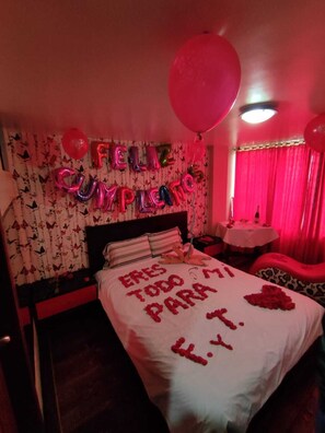 A room with a bed, a wall with balloons spelling "FELIZ CUMPLEAÑOS," and a message on the bed. - HOSTAL LA PERLA DEL SUR AF (Quito)