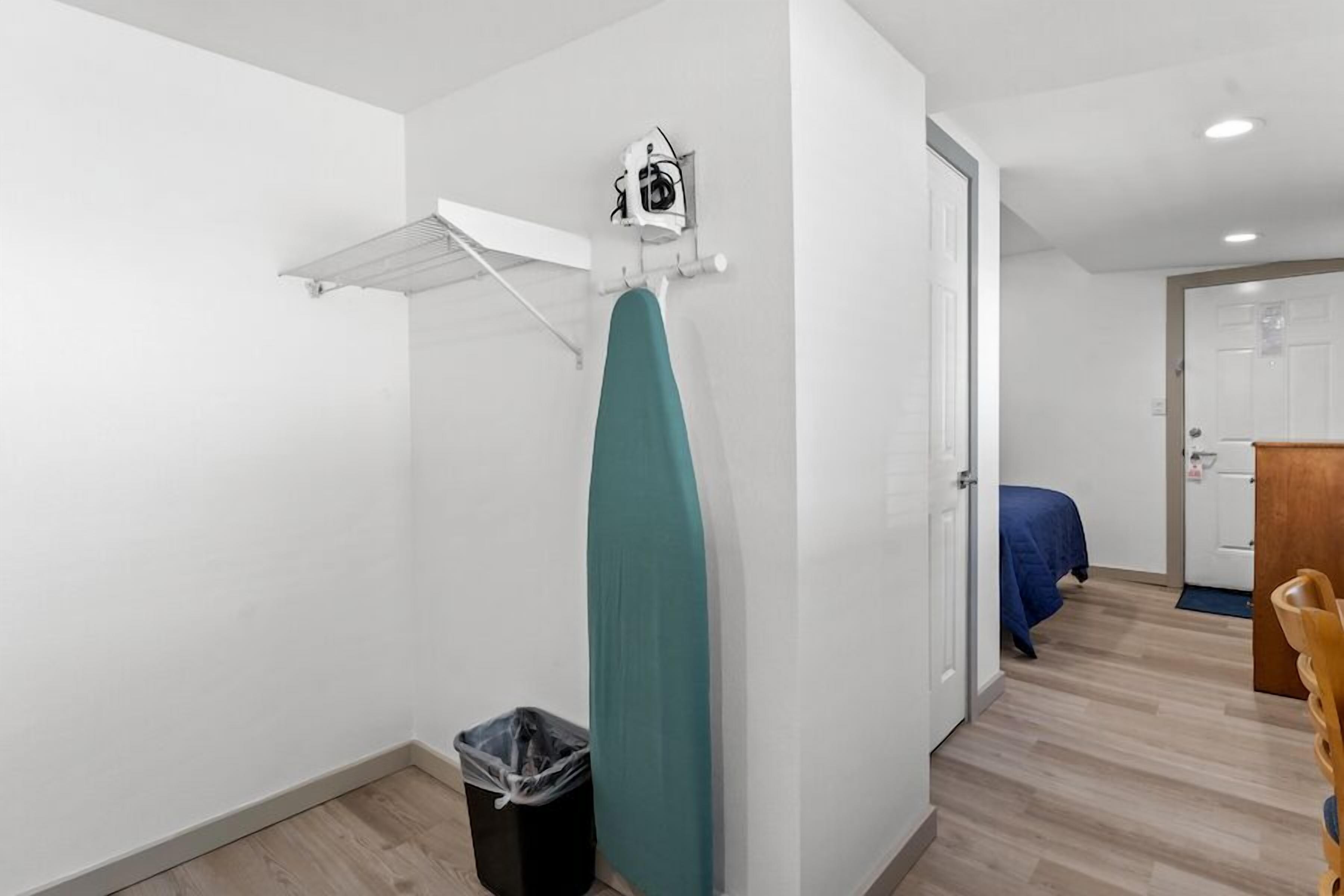 A compact room with a single bed, a small table, and a door leading to another room.