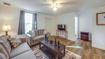 Ein Wohnzimmer mit Sofa, Couchtisch und Fernseher.