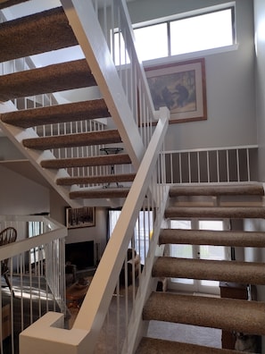 Uma escadaria com corrimão branco e degraus revestidos de carpete.