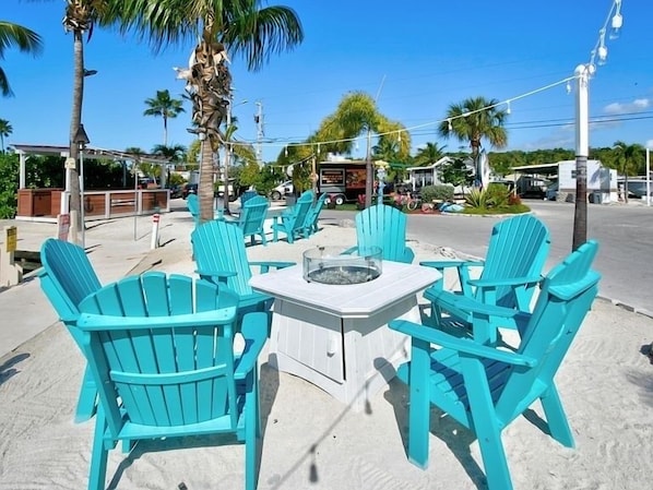 Relax in style with a comfortable seating area featuring a table and four Adirondack chairs.