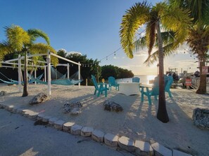 A beachside area with a white gazebo, blue chairs, and a table set for dining. - Casa Seahorse Getaway, Key Largo! (Key Largo)