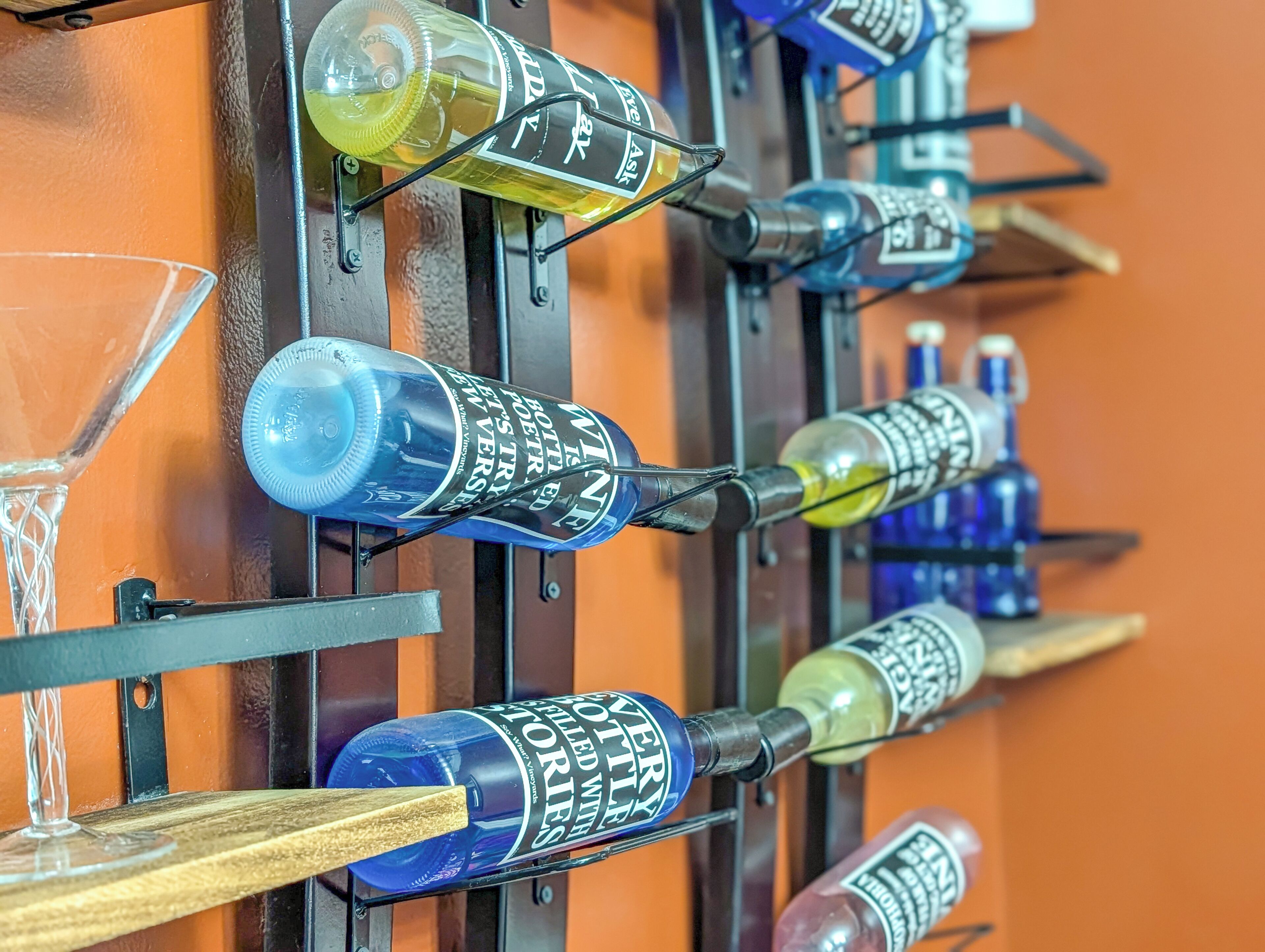 A wall-mounted display of various wine bottles and glasses.