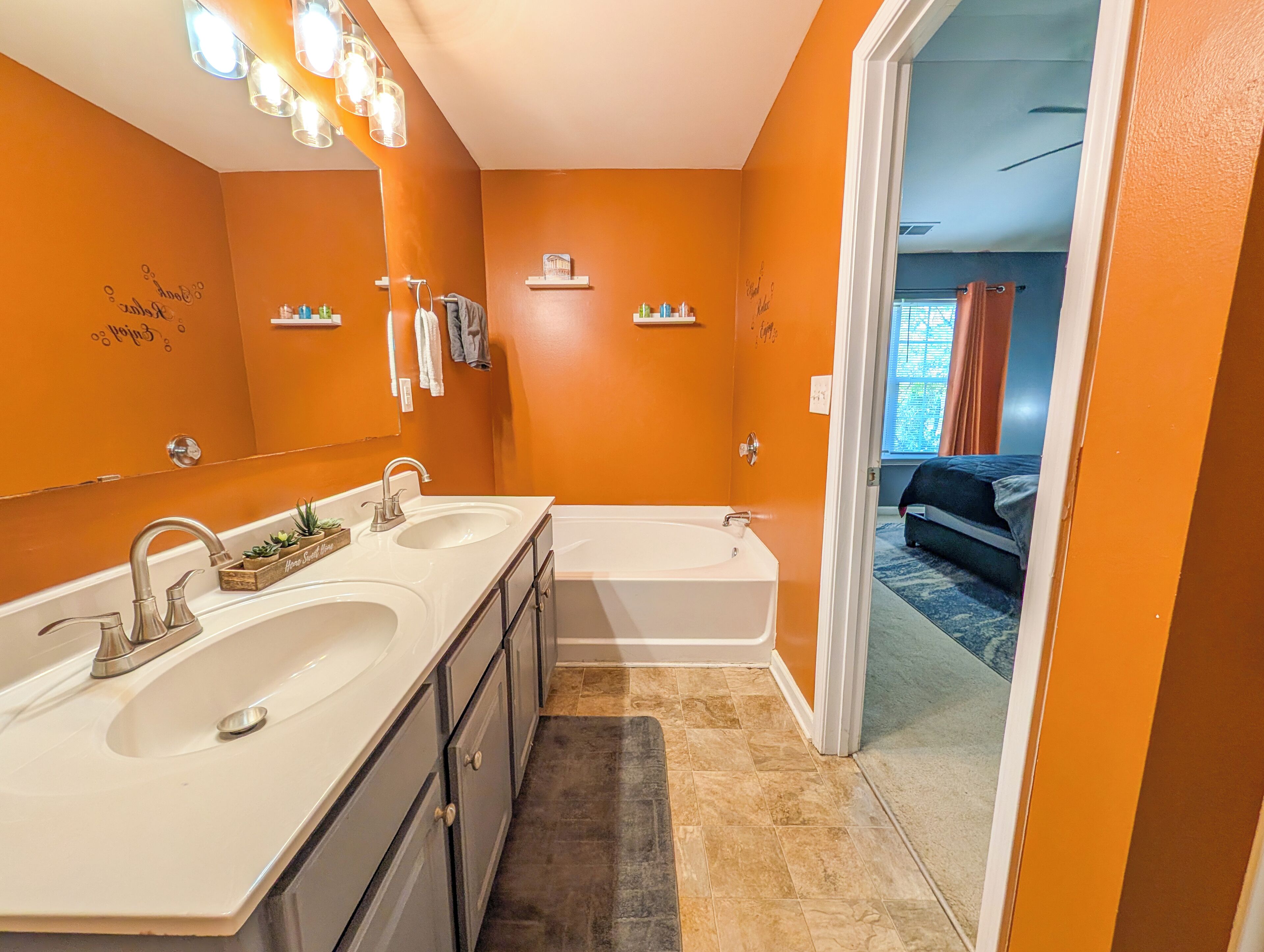 A bathroom with two sinks, a bathtub, and a mirror.