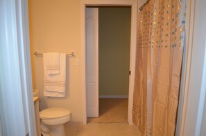 A bathroom with a toilet, a towel rack, and a shower curtain. -  Resort Style Vacation Condo with keyless entry (Palm Beach Gardens)