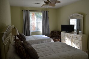 A bedroom with two beds, a TV, a dresser, and a ceiling fan. -  Resort Style Vacation Condo with keyless entry (Palm Beach Gardens)