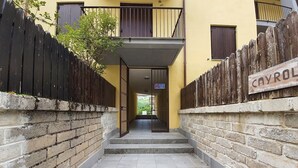 Un conjunto de escalones de hormigón que conducen a la entrada de un edificio, con una valla de madera a cada lado.