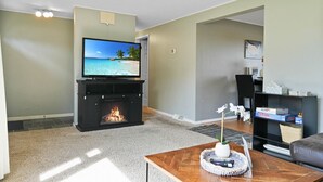 A living room with a fireplace, a television, and a coffee table.