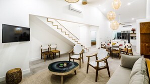 A modern living room with a staircase, dining area, and kitchen. - Newly Renovated, Beachfront, 3 bed Condo on Exclusive Langosta Beach! (Tamarindo, Guanacaste Province)