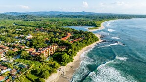 An aerial view of a coastal resort with beachfront properties, a beach, and a river. - Newly Renovated, Beachfront, 3 bed Condo on Exclusive Langosta Beach! (Tamarindo, Guanacaste Province)