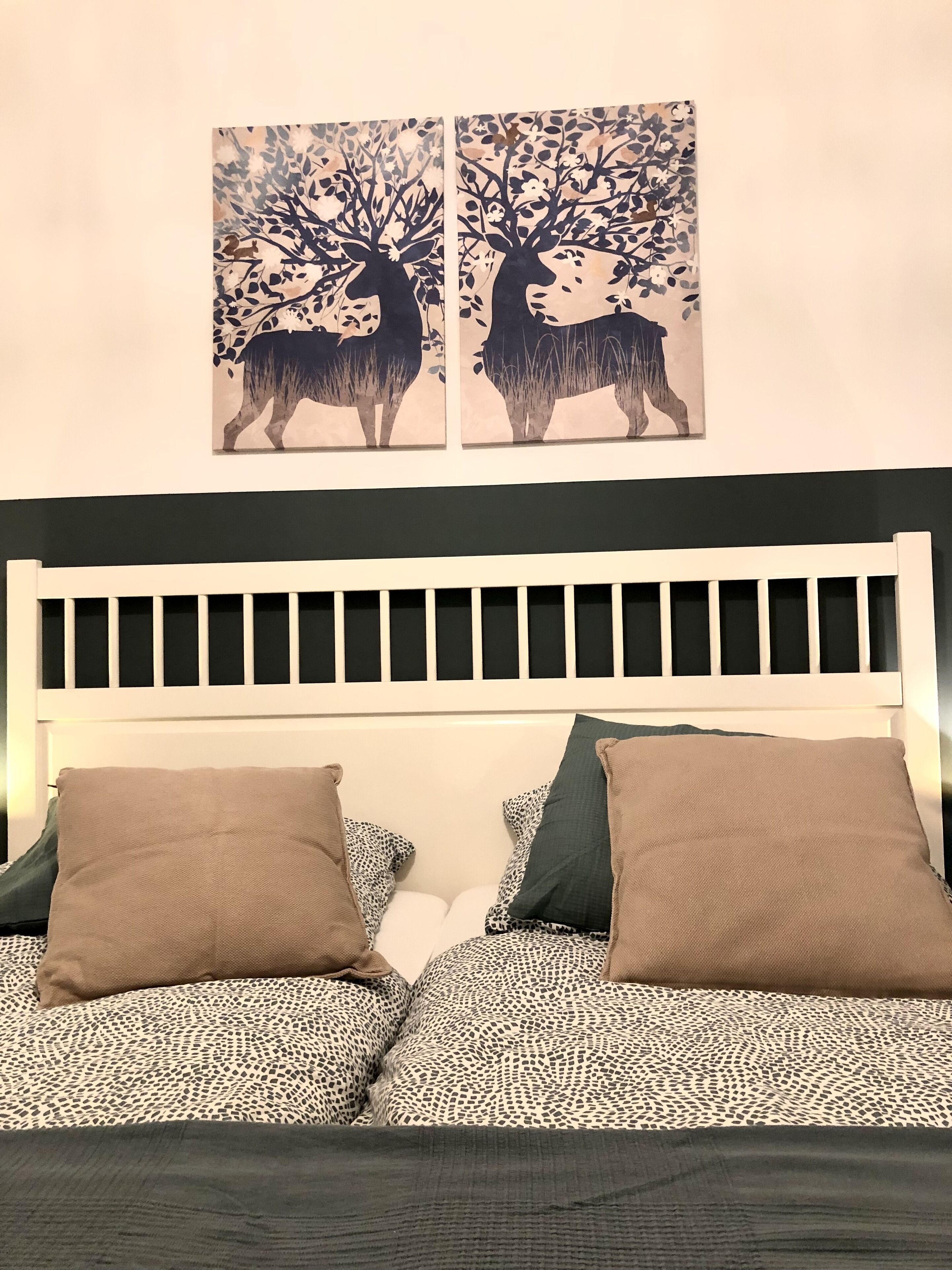 A bed with a white headboard, two brown pillows, and a patterned bedspread.