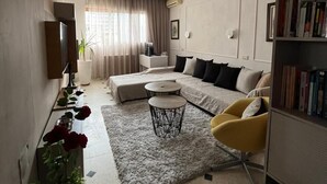 Un salon moderne avec un canapé, une table basse et une bibliothèque.
