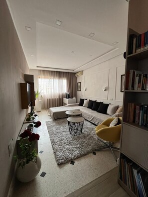 Una sala de estar moderna con un sofá, una mesa de centro y una estantería.