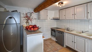 A kitchen with white cabinets, a stainless steel refrigerator, a wooden countertop, and a tiled backsplash. - A peaceful house in Provence with a pool, located between the Luberon, Avignon, and Mont Ventoux (Monteux)
