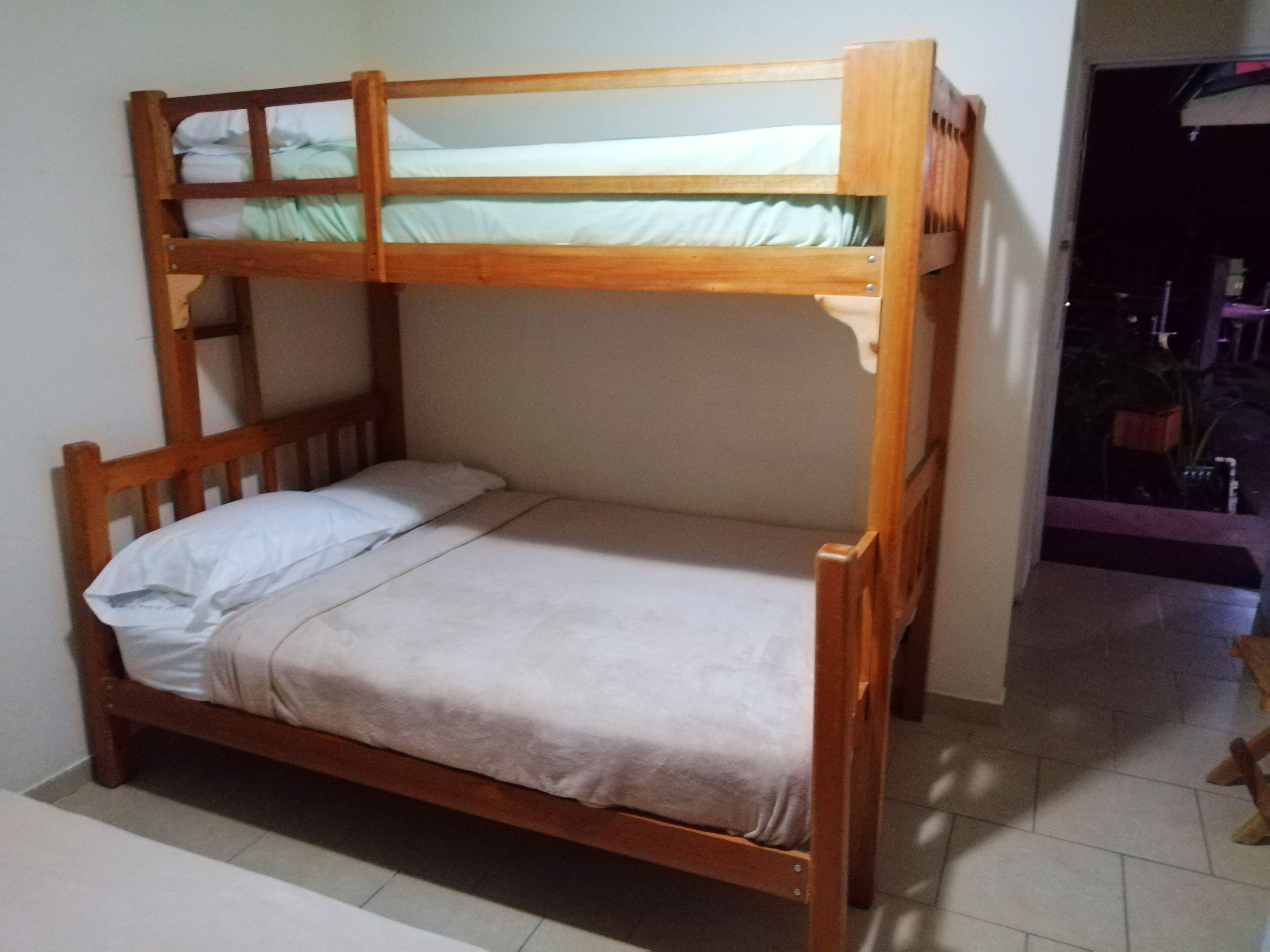 A bunk bed with a wooden frame and a single lower bunk.