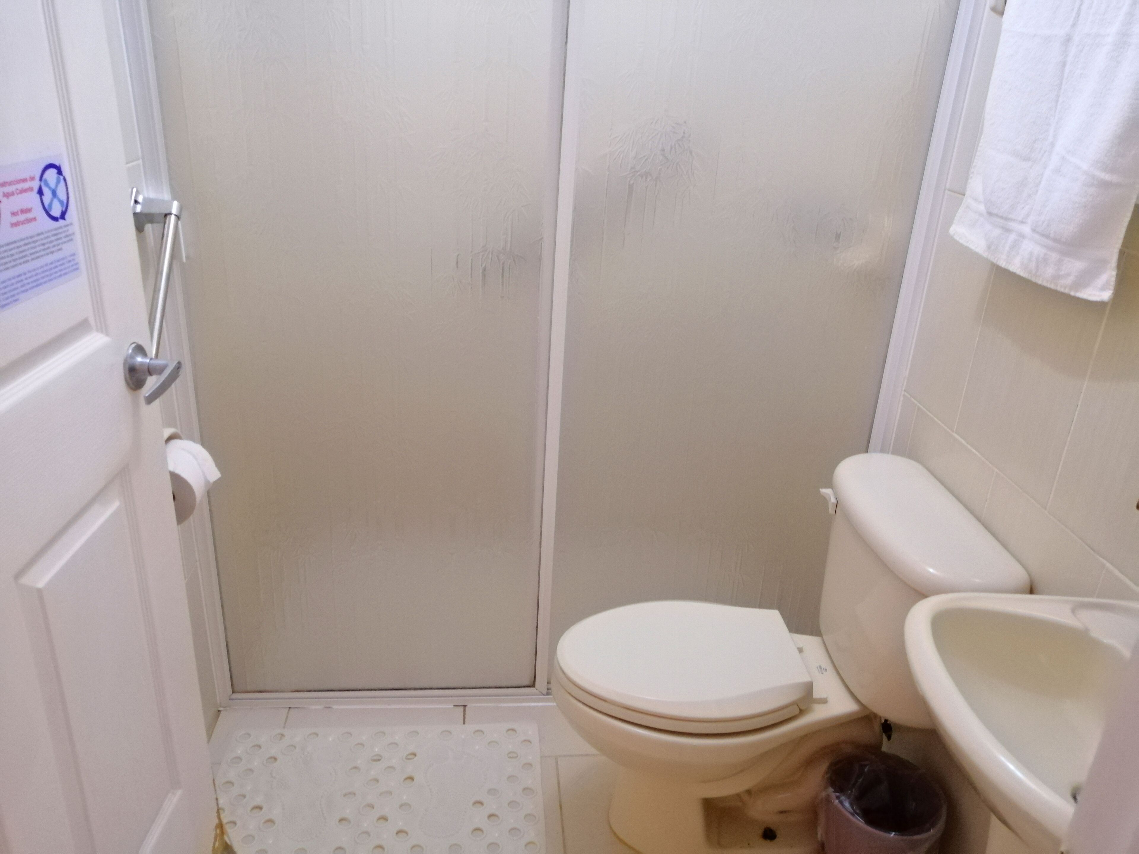 A small bathroom with a toilet, bidet, and shower area.