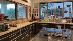 Eine moderne Küche mit dunklen Schränken, einer Granitabdeckung und einem großen Fenster.