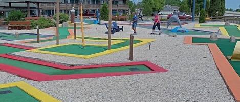 Un terrain de jeux avec des aires de jeux colorées et un panneau indiquant l’emplacement du restaurant Village Inn.