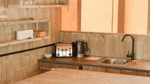 A kitchen with wooden walls, a table, chairs, a toaster, a kettle, and a sink. - Koondrook Retreat (Koondrook)