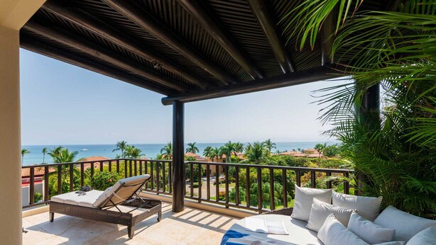 A covered outdoor seating area with a view of the ocean, a lounge chair, and a sofa with cushions. - PH Vista Encanto in El Encanto by Mita Residential. Golf & Ocean View, Pool, Golf Cart (Punta Mita)