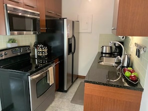 Enjoy cooking in this well-equipped kitchen with a stove, oven, microwave, and refrigerator.