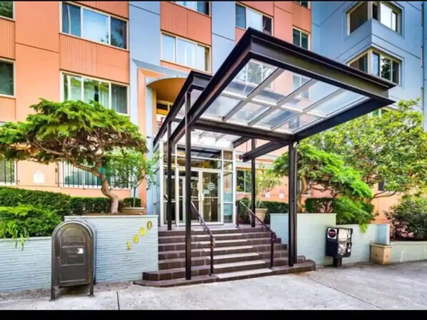 Steps lead up to a glass-enclosed entrance offering a view of the interior.