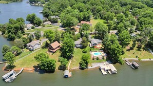 An aerial view of a lakeside community with houses, a dock, and a swimming pool. - Lakeside Sunsets - Private Dock, Hot Tub & Firepit (Moneta)
