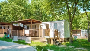 A mobile home with a wooden deck and a covered porch. - Mobilehome with air conditioning, terrace and water park (Peschiera del Garda)