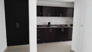 Une cuisine moderne avec des meubles de couleur sombre et un plan de travail.