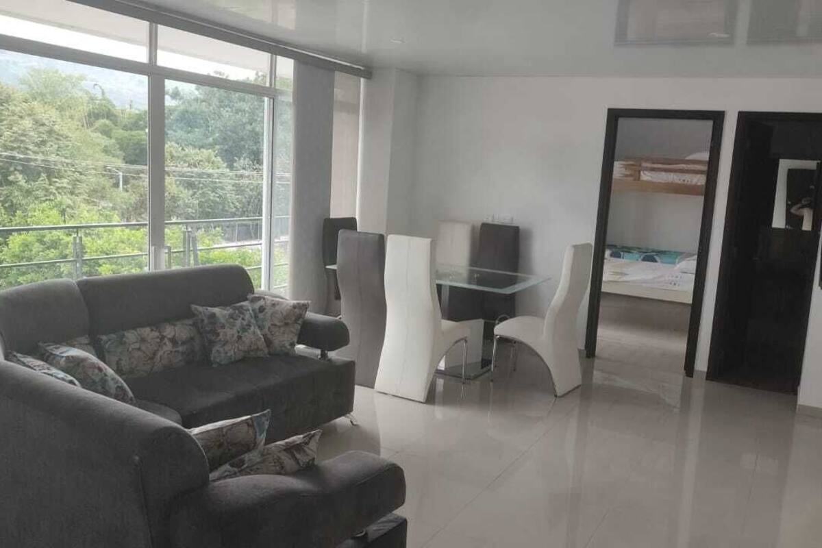 Een moderne woonkamer met een bank, een glazen tafel en een televisie.