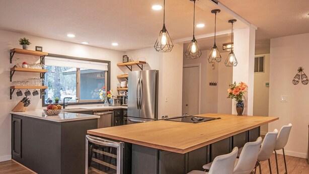 A modern kitchen with a central island, bar stools, and pendant lighting. - 5 Wickiup - Hot Tub, Updated, Ping Pong, SHARC Passes, Bikes (Sunriver)