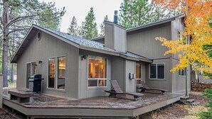 A modern cabin with a deck, large windows, and a chimney. - 5 Wickiup - Hot Tub, Updated, Ping Pong, SHARC Passes, Bikes (Sunriver)