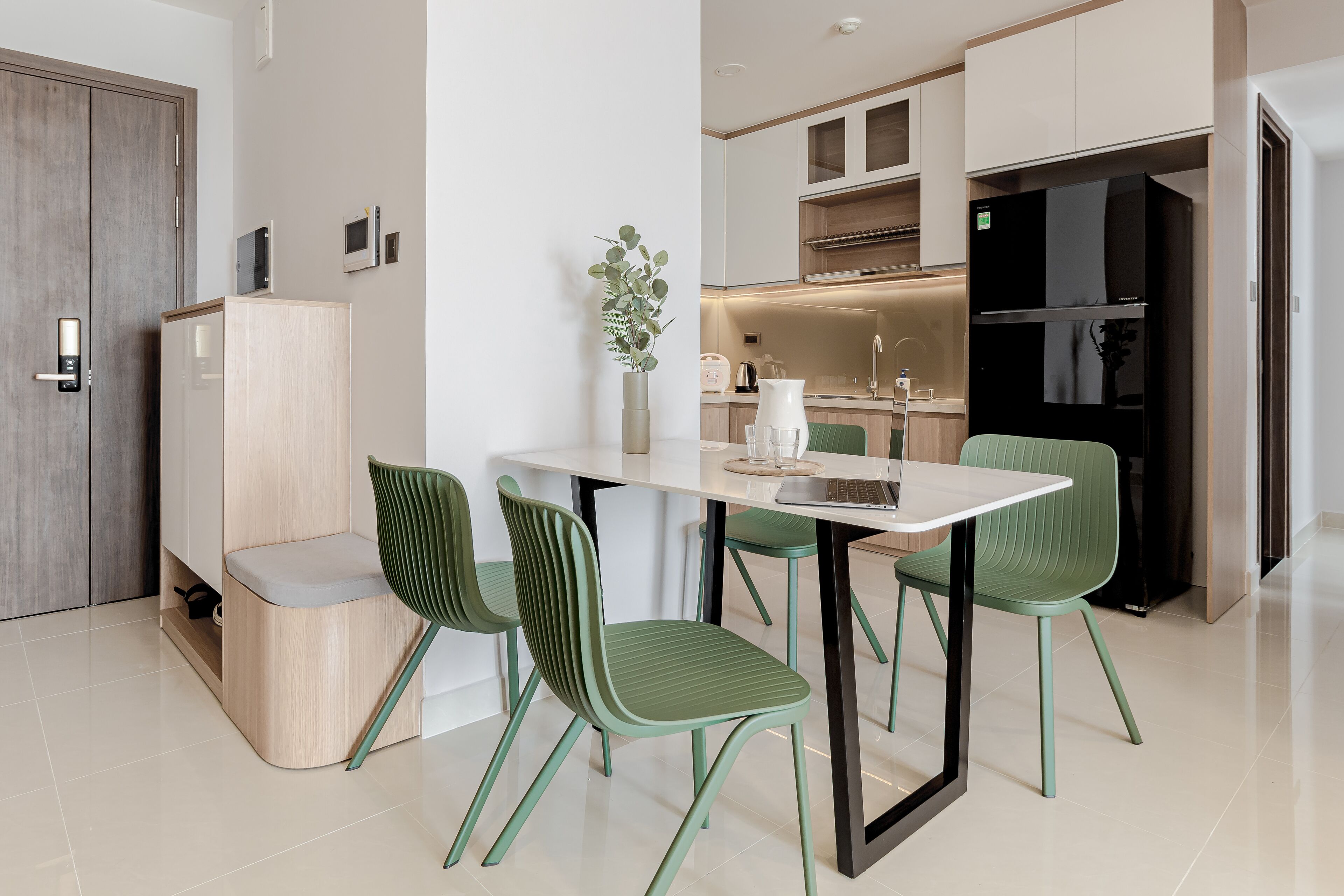 Eine moderne Küche mit Essbereich, inklusive Tisch, Stühlen und einem Kühlschrank.