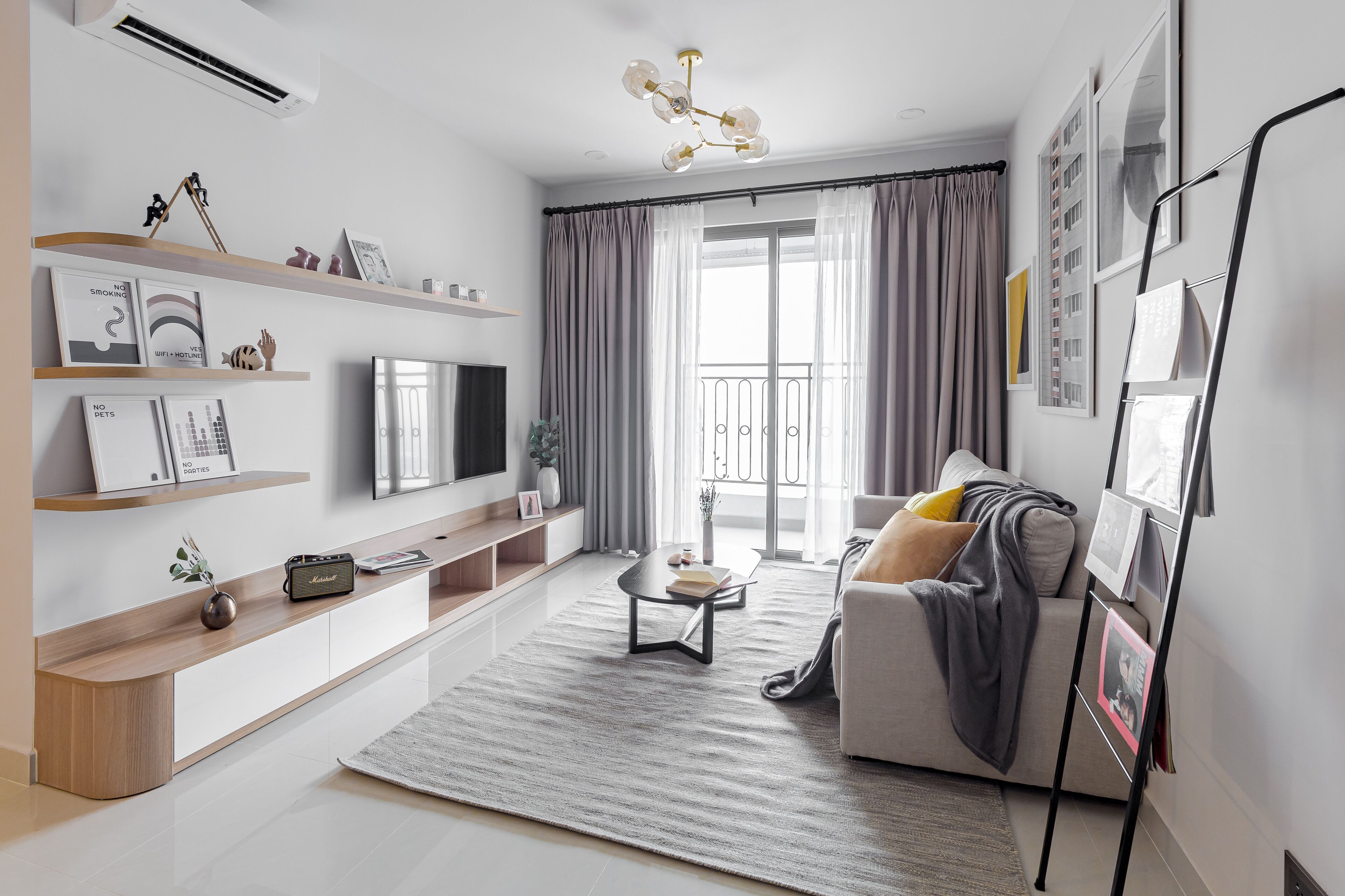 Una sala de estar moderna con una televisión de pantalla plana, un sofá, una mesa de centro y una estantería.