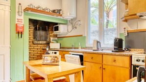 Una cocina compacta con horno de ladrillo, microondas y electrodomésticos modernos.