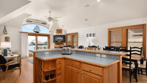 A modern kitchen with wooden cabinets, a built-in island, and a view of the outside.
