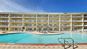 Un hôtel à plusieurs étages doté d’une piscine centrale, de balcons et d’espaces de détente en plein air.