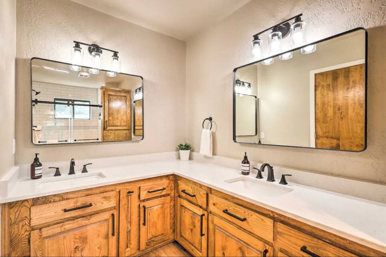 A bathroom with two sinks, wooden cabinets, and large mirrors.