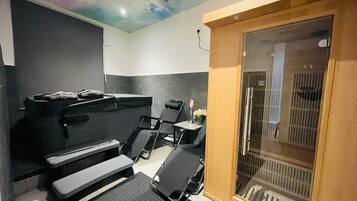 A spa room with a massage table, reclining chairs, and a wooden sliding door.