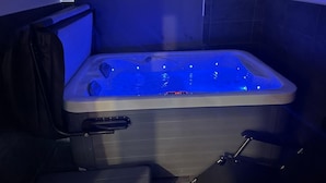 Uma banheira de hidromassagem com painel de controle e uma cadeira.
