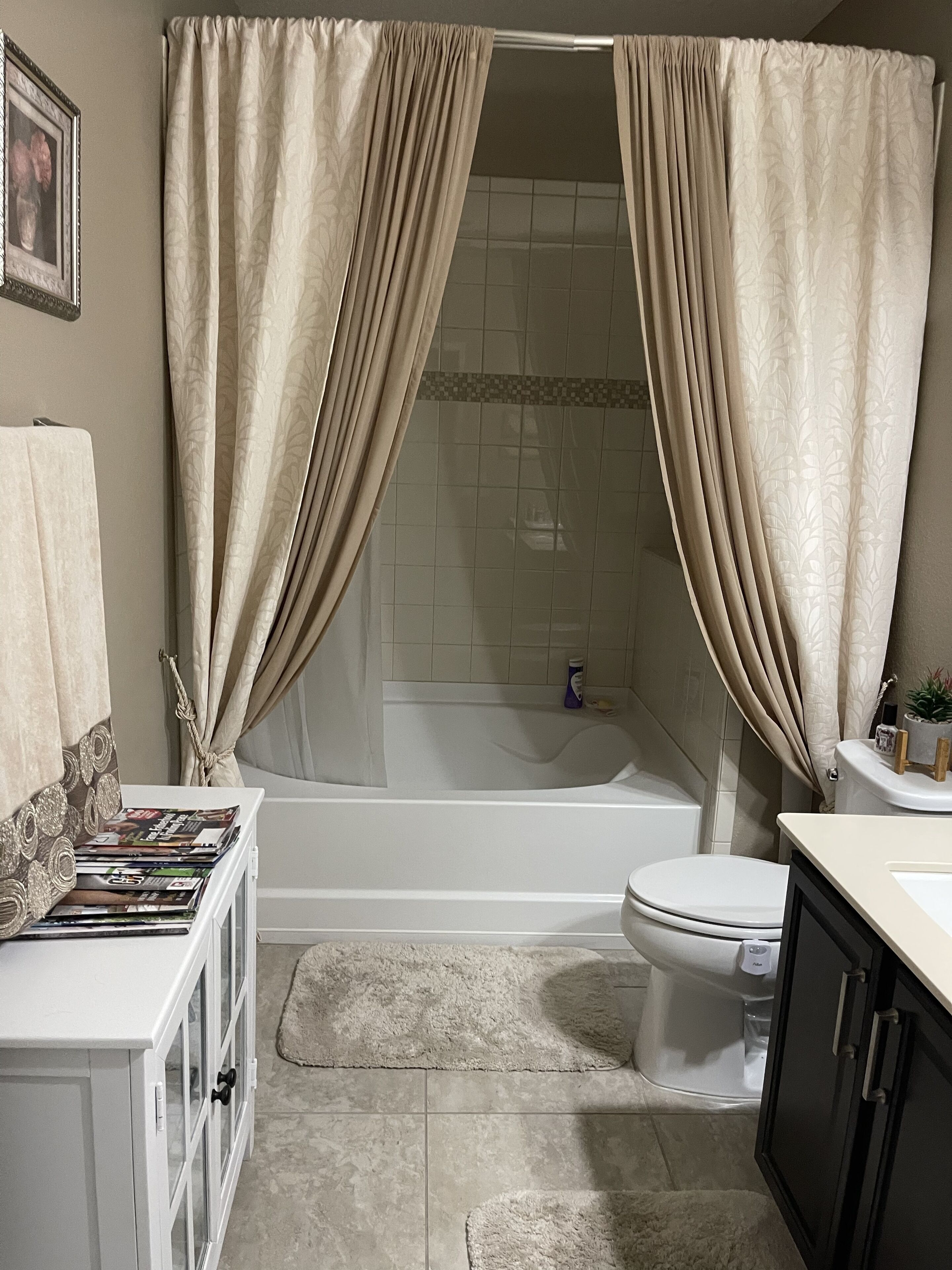 A bathroom with a bathtub, toilet, and a shower area.